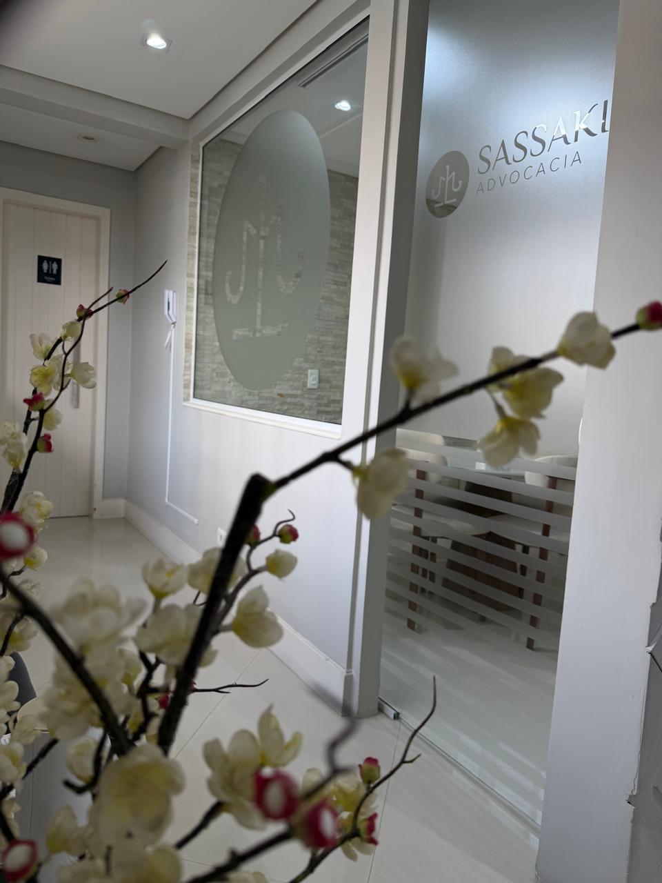 Corredor interno com porta de vidro jateado da Sassaki Advocacia